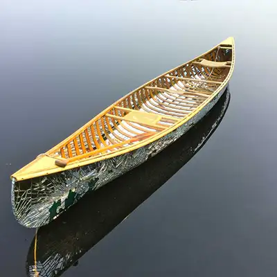 Canoe with mirror fragments floating on still water.