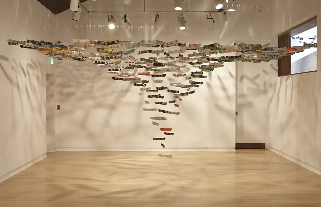 A series of miniature canoe sculptures with beer branding are hanging from the ceiling.